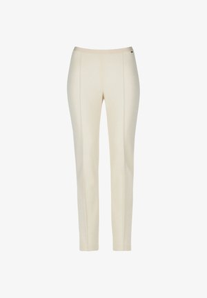 Pantaloni beige chiaro realizzati in tessuto liscio. Presentano un design aderente con cuciture frontali e una vita elastica. Senza tasche né motivi.
