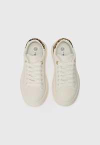 Hvite sneakers med en glatt tekstur, pyntet med en leopardmønsterdetalj på kragen og hvite snøringer, kombinert med detaljer i gullfarge.