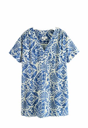 Blouse crème à manches courtes avec un motif floral et géométrique bleu complexe, dotée d'un col en V et de détails froncés aux épaules.