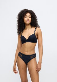 Black lace-trimmed bra and matching panties. The bra has a v-neck design with thin straps, while the panties feature a lace accent and smooth fabric.