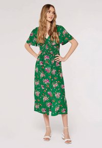Grünes, floral gemustertes Midi-Kleid mit kurzen Ärmeln, gerafftem Oberteil und einem fließenden Rock, der mit mehrfarbigen Blumenmustern durchzogen ist.
