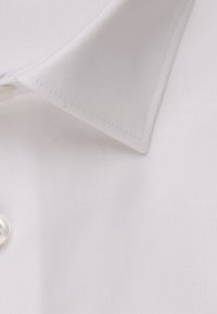Una camicia bianca con colletto classico, tessuto a trama fine e un singolo bottone in madreperla. Aspetto liscio e formale.