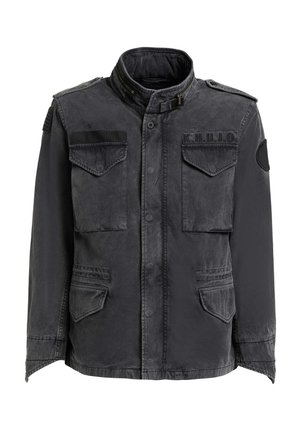 Černá vojenská bunda se čtyřmi předními kapsami s klopami, vysokým límcem s přezkou, nášivkami na ramenou a záplatami na hrudi a rukávu.