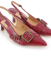 Tacones slingback de cuero rojo con punta afilada, que presentan una hebilla decorativa y un diseño plisado, montados sobre un bloque bajo.