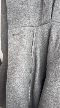 Γκρι ζακέτα από μείγμα μάλλινου υφάσματος σε στενή γραμμή, με πλαϊνό φερμουάρ, λεία υφή και διακριτές ραφές στις ραφές.