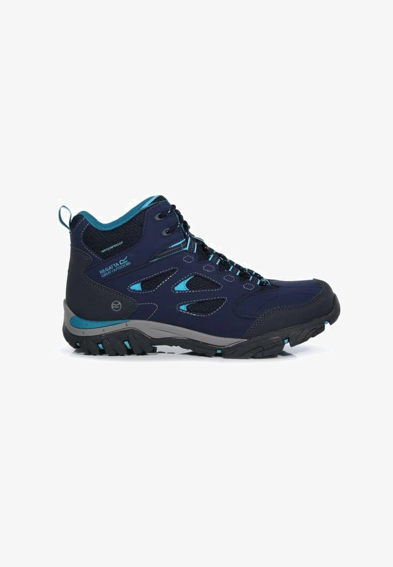 Botte de randonnée imperméable bleu foncé avec des accents noirs et bleu sarcelle, semelle robuste et maintien élevé de la cheville.