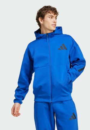 Felpa con zip blu dal finish testurizzato, dotata di cappuccio, dettagli neri e tasche laterali. Fa parte di un completo coordinato.