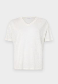 Camiseta blanca de cuello en V, hecha de un tejido ligero y texturizado. Presenta mangas cortas y un corte relajado. Dobladillo liso, diseño simple.