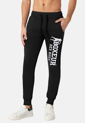 Pantaloni della tuta neri con tasche laterali, polsini elasticizzati e una stampa grafica bianca con "BOXEUR DES RUES." Realizzati in tessuto morbido per il massimo comfort.