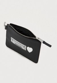 Pungă neagră cu fermoar, cu un grafic alb de armonică și inimă pe față și un inel metalic pentru chei atașat.