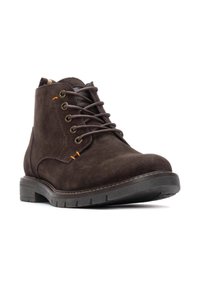 Bota de ante marrón hasta el tobillo con puntera redonda, diseño de cordones, acentos naranjas, ojales de metal y suela de goma texturizada.