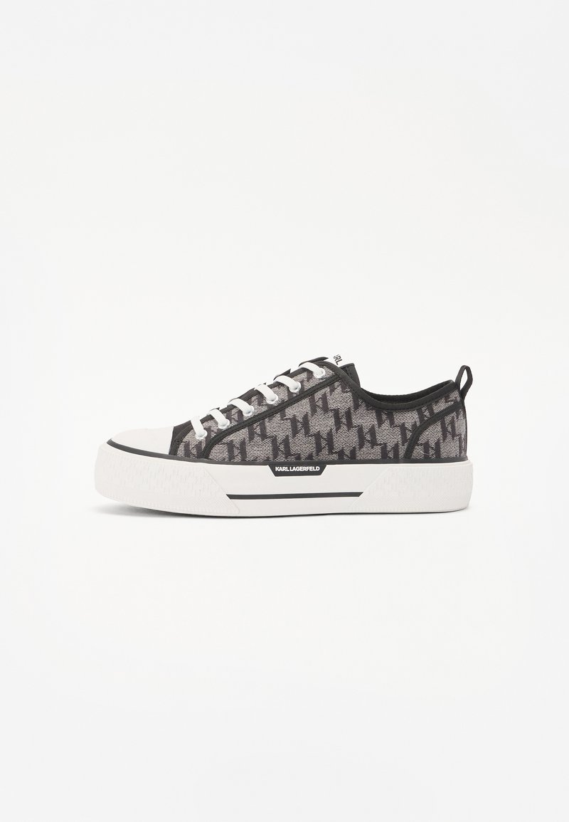 Sivi platneni športni čevlji s houndstooth vzorcem, belim gumijastim podplatom, črnimi detajli in belimi vezalkami, ki imajo logotip ob strani.