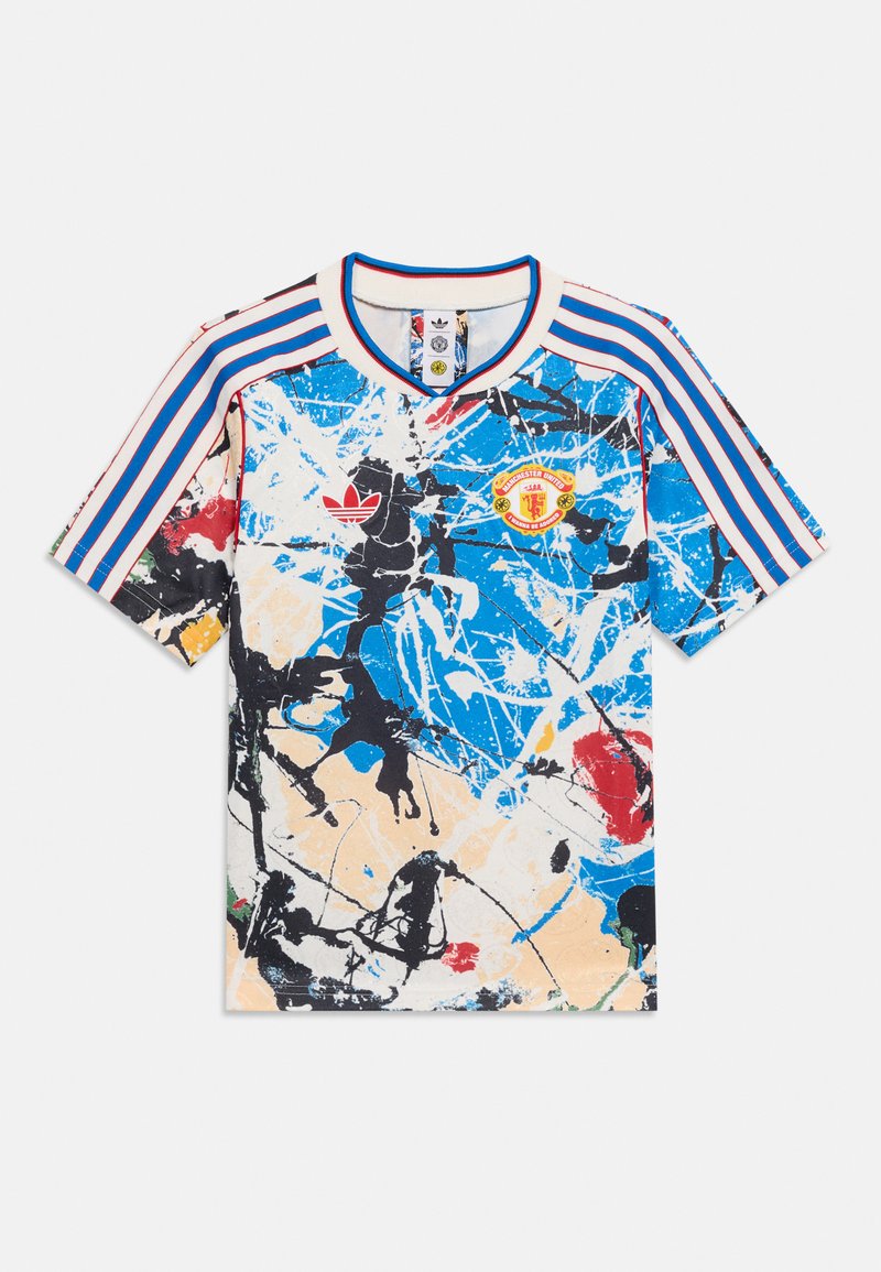 Κοντομάνικο ποδοσφαιρικό φανέλα Adidas με αφηρημένες πιτσιλιές χρωμάτων σε μπλε, μαύρο, κόκκινο και μπεζ, με το σήμα της Manchester United και μπλε ριγέ μανίκια.
