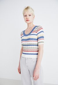 Majica s kratkimi rokavi in ribanim materialom z okroglo izrezano ovratnikom, ki vsebuje večbarvne vodoravne črte v modri, zeleni, rdeči in beli barvi.