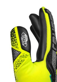 Guanto da portiere con tessuto giallo neon, palmo in lattice nero, accenti di grip texture e motivi esagonali sul dorso e sull'area del polso.