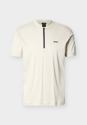 Tricou polo de culoare alb-închis cu mâneci scurte, fermoar negru pe jumătate și logo-ul "BOSS" pe pieptul stâng, pe un fundal simplu.