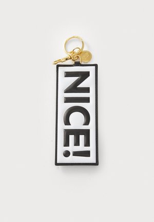 Svart og hvit nøkkelring med ordet "NICE!" i store, fete bokstaver. Rektangulær form med en gyllen metallring og hardware-detaljer.
