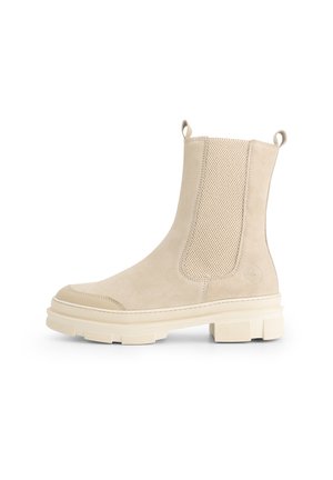 Beige suède enkellaars met chunky zool, elastische zijpanelen en trekstrips aan de hiel en voorkant.