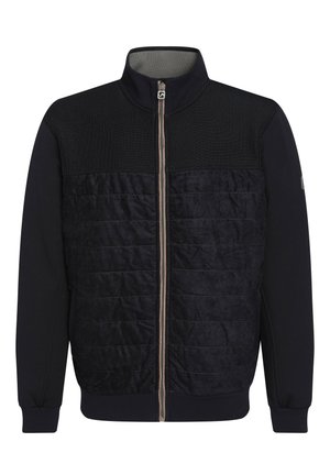 Vīriešu zip-up jakas tumši zilā krāsā, ar teksturētu adītu augšdaļu un kviltētu apakšdaļu. Ribotas piedurknes un apkakle, ar kontrastējošu rāvējslēdzēja detaļu.
