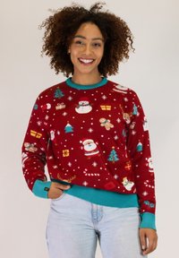 Red sweater featuring Christmas-themed patterns including Santa, snowmen, and trees. Ribbed turquoise cuffs and hem. Soft, textured material.