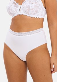 Culotte haute blanche en tissu doux avec une ceinture en dentelle accentuée de détails complexes et d'une texture lisse.