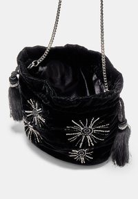 Borsa a secchiello in velluto nero con motivi a stella in perline d'argento, tracolla a catena e nappine su entrambi i lati. Texture morbida con apertura a coulisse.