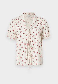 Blusa floral con mangas cortas, fondo color crema, pequeño patrón de rosas rojas, lazos en la cintura, tejido de textura suave, detalle en el cuello.