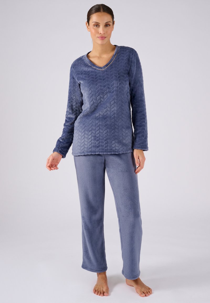 Conjunto de pijama de dos piezas en suave forro polar azul. Camiseta de manga larga con patrón de chevrón y escote en V, combinada con pantalones rectos sólidos.