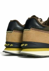 Zapatilla de ante marrón y textil verde olivo con acentos negros y logotipo amarillo "OFF". Presenta una suela en capas con franjas blancas y amarillas.