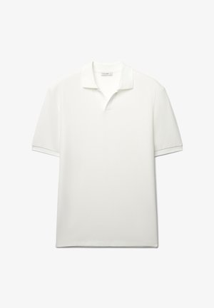 Polo bianca realizzata in tessuto strutturato, con colletto classico, maniche corte e orlo dritto.