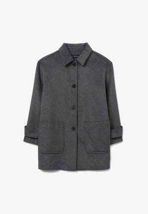 Grijze wollen jas met een kraag, knopen vooraan en twee grote patchzakken. Heeft opgerolde mouwen en een zachte textuur.