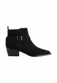Botines de ante negro con punta afilada, tacón bajo apilado, tiras decorativas y detalle de hebilla, y una lengüeta en la parte trasera.