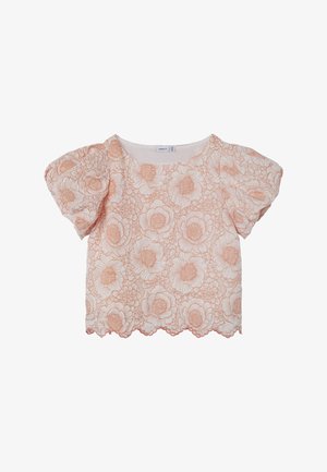 Floral-patterned blouse in light peach and cream, featuring short puff sleeves, scalloped hem, and textured fabric with raised flower details.