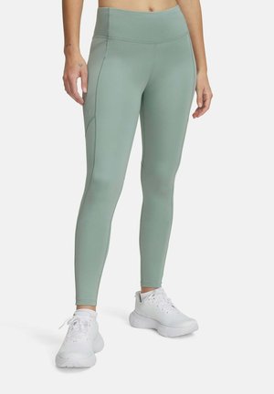 Mint green leggings with a high waistband, sleek design, and side seam accents, paired with white athletic shoes.