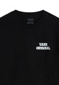 Camiseta de algodón negra con el texto blanco "VANS ORIGINAL" en una fuente audaz y redondeada. Corte clásico con un cuello redondo acanalado.