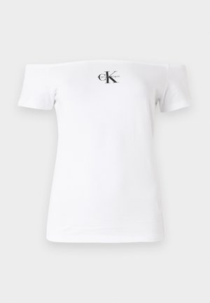 Hvid off-the-shoulder T-shirt med korte ærmer, lavet af bomuldsstof, prydet med sort "CK" logo og tekst trykt på forsiden. Glat tekstur.