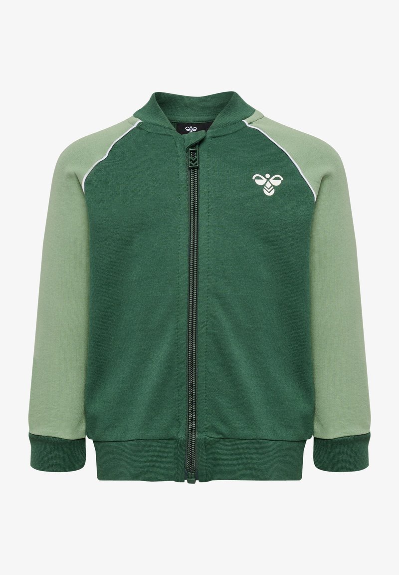 Grön zip-up jacka med ljusgröna ärmar, ribbade mudd och krage. Har vit passpoal och en liten logotyp på bröstet. Mjukt material.