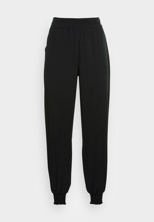 Black, elasticated joggers with a smooth fabric finish, featuring a high waistband and gathered cuffs at the ankles. Classic, casual shape.