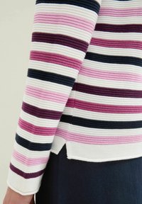 Pull rayé avec des rayures horizontales en rose, violet foncé, noir et blanc. Fabriqué en tissu texturé avec des fentes sur les côtés à l'ourlet.
