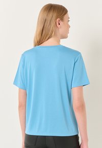 Korte mouwen, lichtblauw T-shirt van gladde stof, met een klassieke ronde halslijn en een ontspannen pasvorm, zonder zichtbare patronen of details.