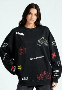 Felpa nera oversize in cotone con vari ricami, tra cui testo, una rosa e grafiche in rosso, bianco e giallo.