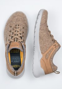 Braune Filzschuhe mit hellbraunen Wildlederakzenten, grauem Stofffutter und einer strukturierten weißen Gummisohle. Verfügt über beiges Schnürsenkel und ein umweltfreundliches Innenleben.