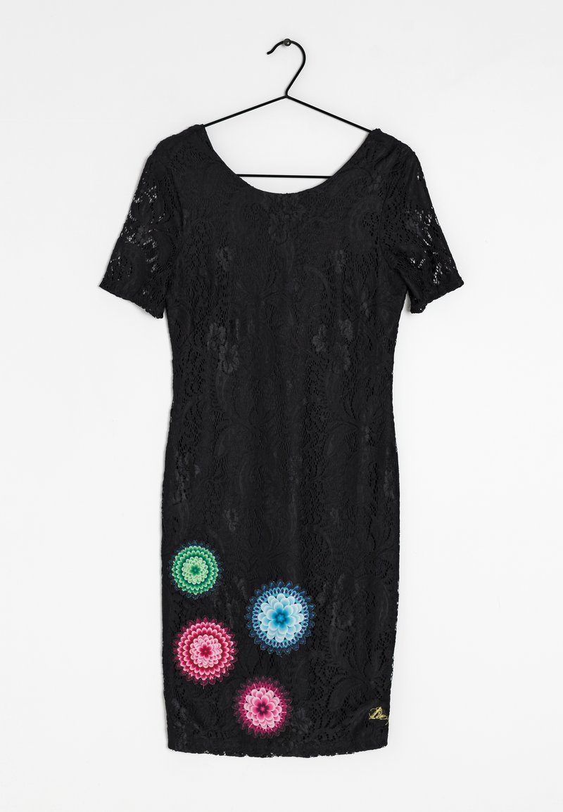 Vestido negro de encaje con mangas cortas, que presenta un colorido bordado floral en verde, azul, rosa y púrpura en el lado inferior izquierdo.