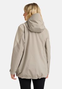 Giacca impermeabile beige chiaro con cappuccio, caratterizzata da una texture liscia, una vestibilità comoda e un orlo cinchato per uno stile regolabile.
