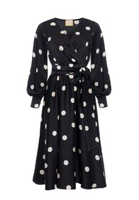 Czarna sukienka typu wrap z białymi kropkami, długimi bufiastymi rękawami, wiązaniem w talii oraz pełną spódnicą. Gładki materiał z delikatnym połyskiem.