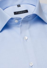 Camicia azzurra ETERNA comfort fit con texture intrecciata, colletto a punta e bottoni in plastica bianchi con una classica pattina a due bottoni.