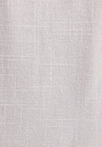 Tissu en lin gris clair avec un tissage texturé, présentant un motif de grille subtil. Le matériau semble doux et respirant.