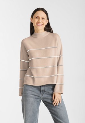 Lichtbeige gebreide trui met witte horizontale strepen, hoge hals en cropped pasvorm. Zachte textuur en lange mouwen met een ontspannen stijl.