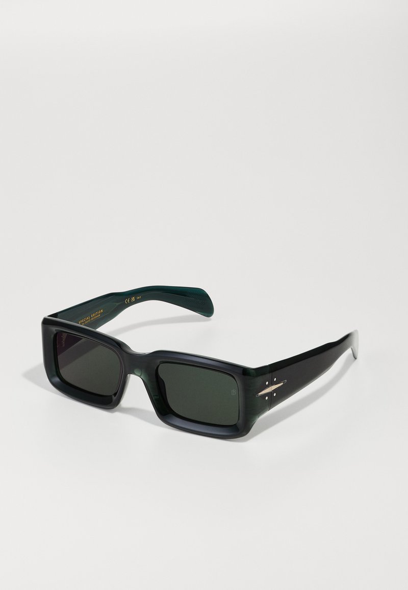 Ochelari de soare pătrați, fabricați din plastic verde închis, cu lentile întunecate și accente argintii pe ramă. Include temple texturate și detalii cu logo.