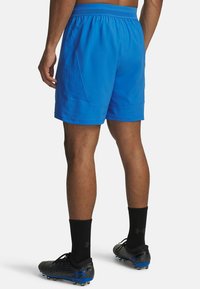 Zili sporta šorti, izgatavoti no viegla materiāla, ar elastīgu jostu un sānu kabatām. Valkāti ar melniem sporta apaviem un zeķēm.